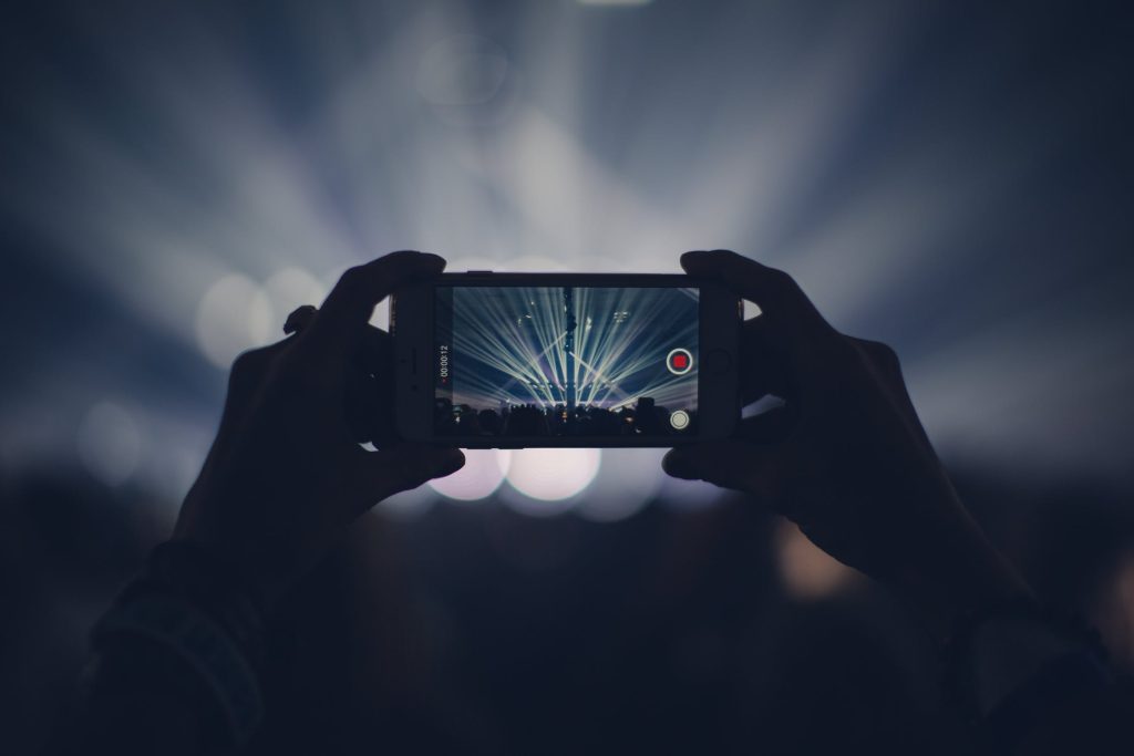 taking a video on phone at concert
