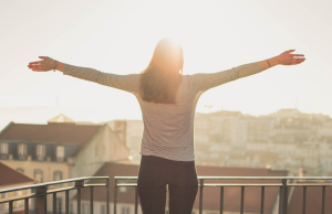 woman happy on a balcony at sunset